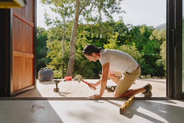 Uomo che lavora diligentemente su un piano di calpestio di legno di fronte a una cabina